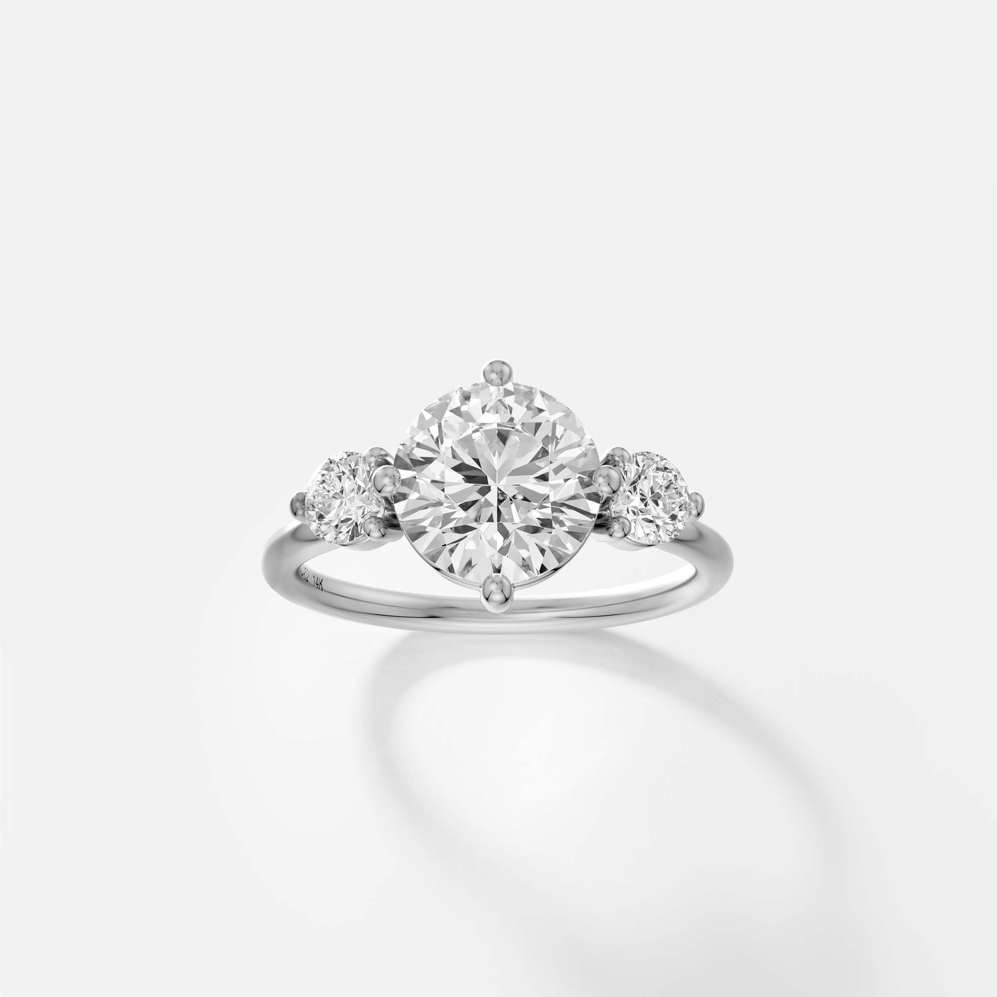 Platinum engagement ring with round brilliant diamond center and round accent stones in prong setting on delicate band