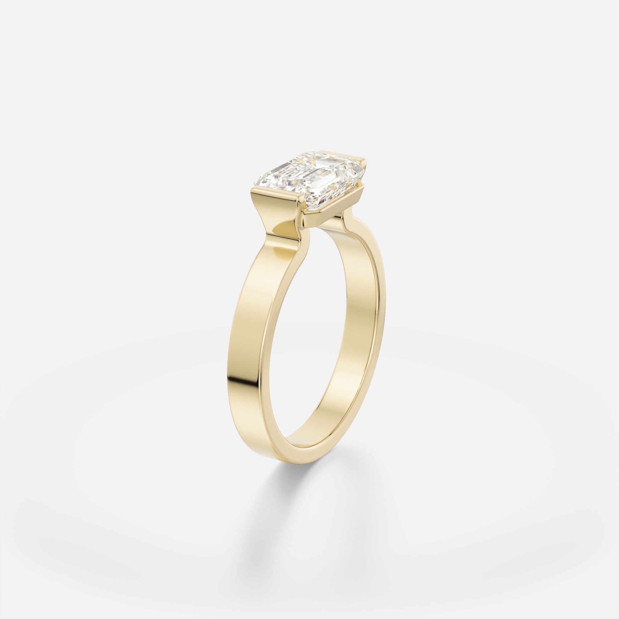 Silvi east west emerald diamond tapered partial bezel engagement ring angled side view