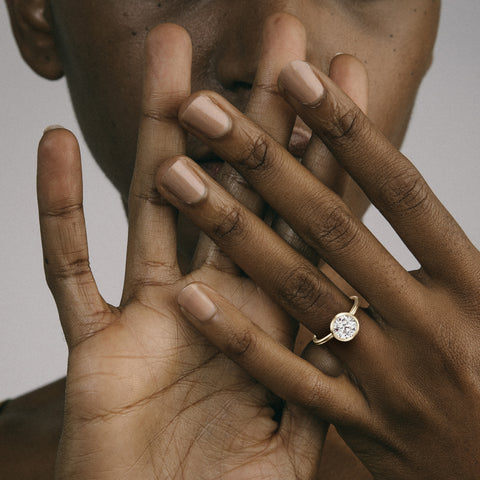 Close view of round brilliant diamond in thin bezel on slim round profile band