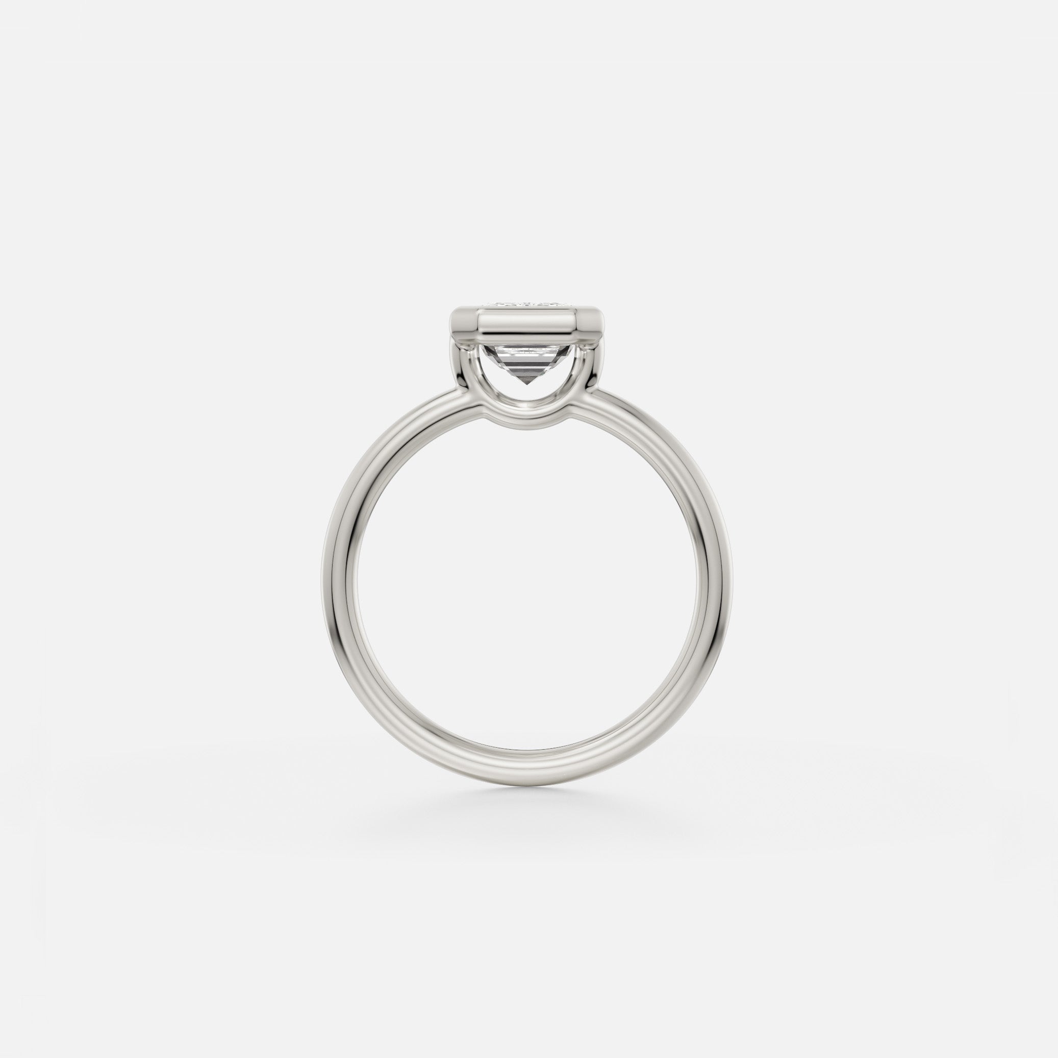 Platinum thin round profile band engagement ring with bezel set round diamond