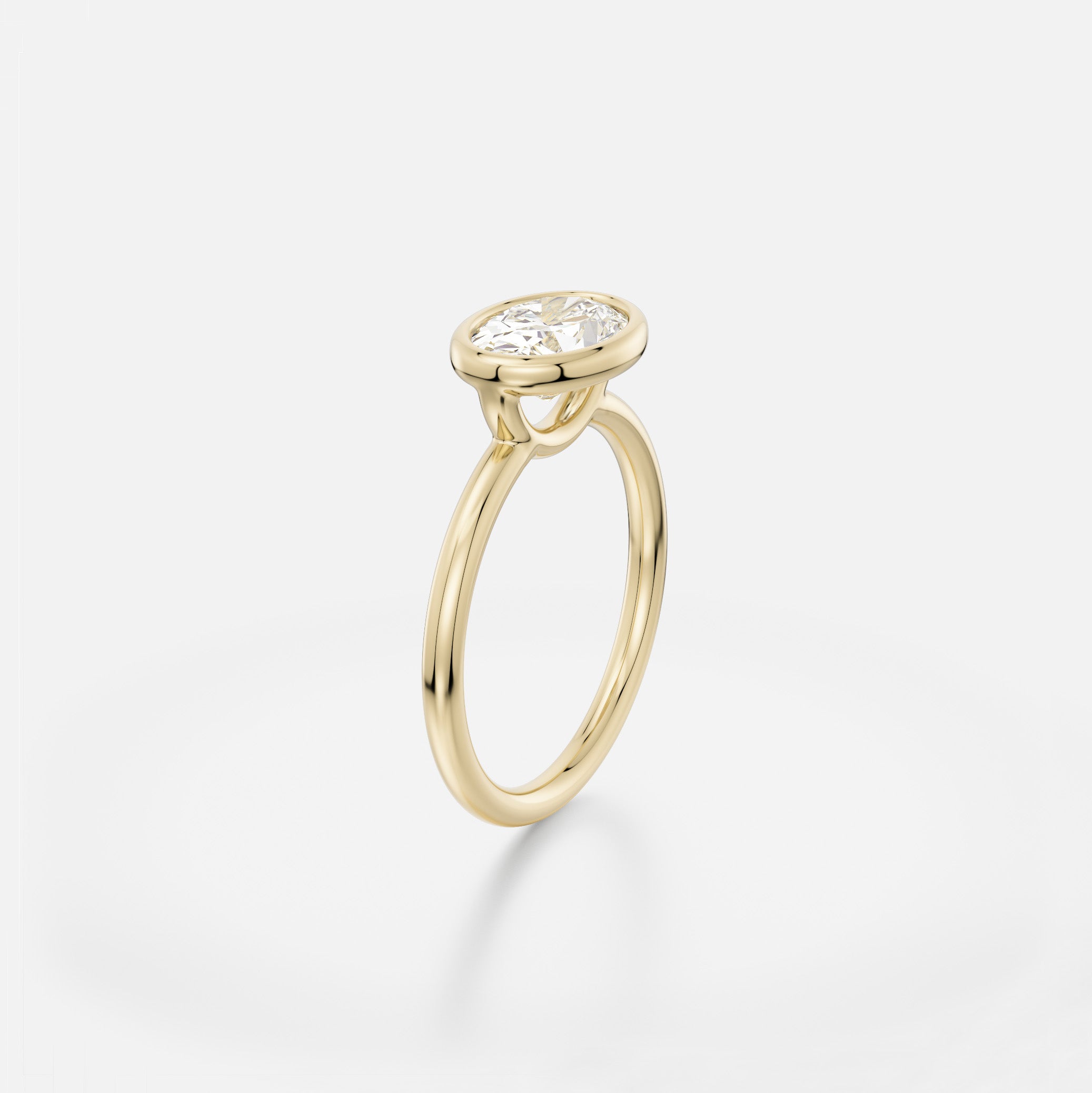 Delicate round profile band engagement ring with 1.5 ct oval diamond set east west in minimalist bezel