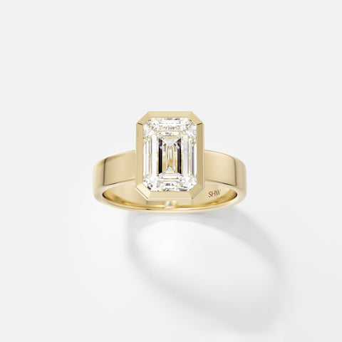 14k yellow gold wide flat band engagement ring with 2.50 carat emerald-cut diamond in thin bezel setting