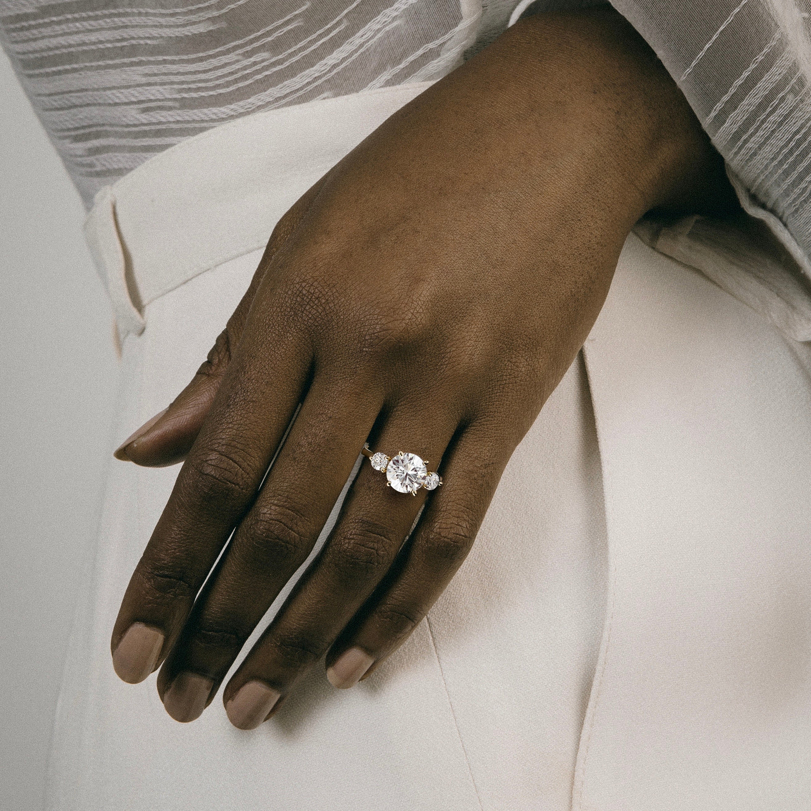 Kala round brilliant diamond three stone engagement ring worn on hand