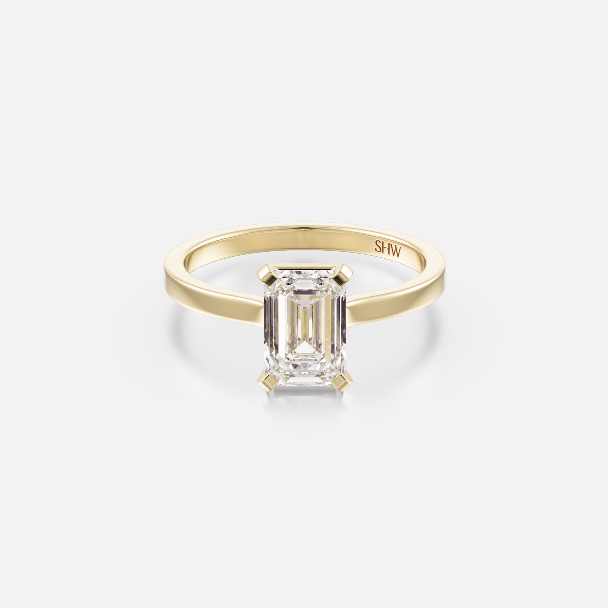 14k yellow gold thin flat band engagement ring with 1.50 carat emerald-cut diamond set north south with corner prongs