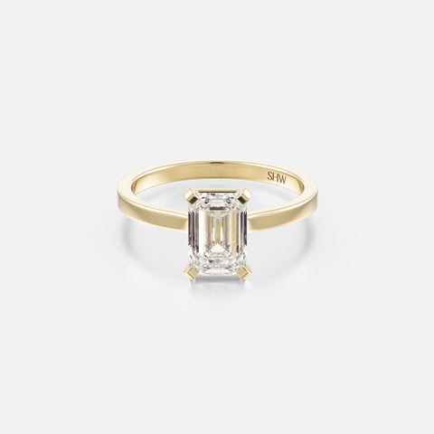 14k yellow gold thin flat band engagement ring with 1.50 carat emerald-cut diamond set north south with corner prongs