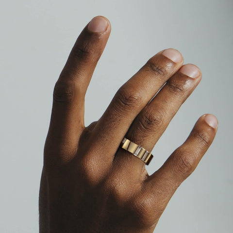 Modern 6mm gold wedding band with vertical baguette diamonds shown worn in natural light
