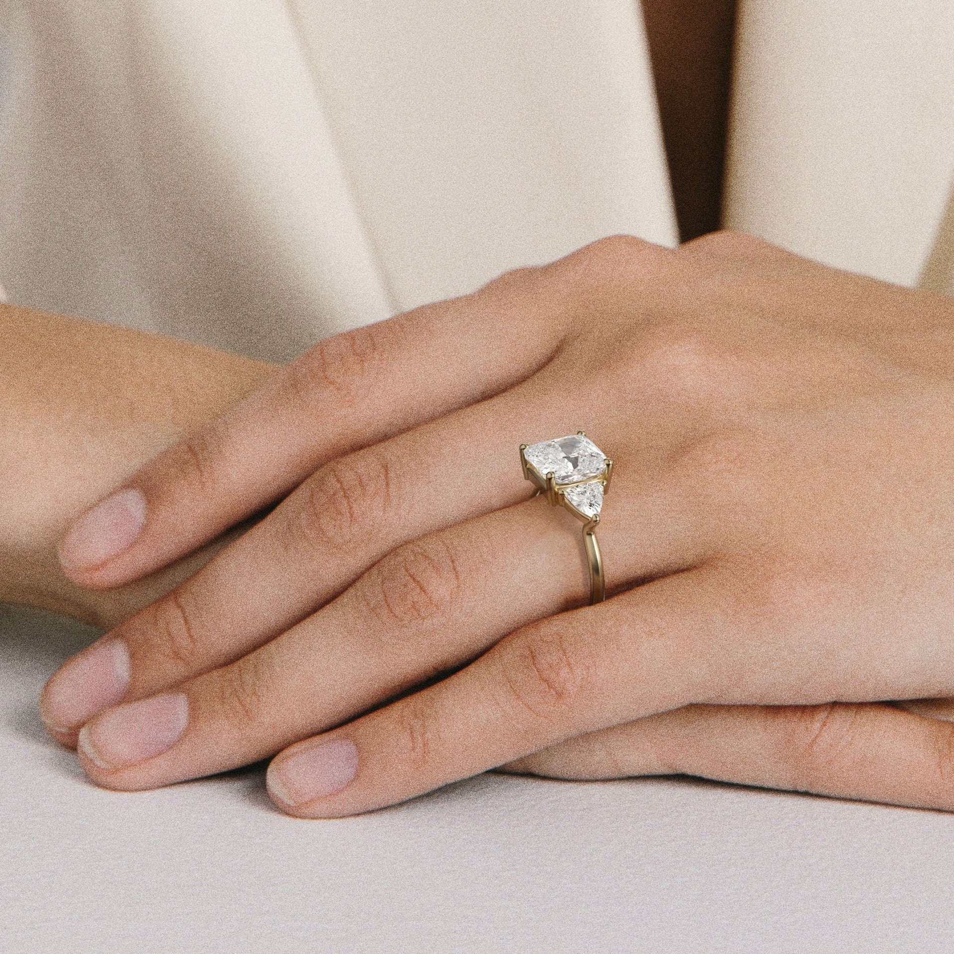 close view of 3.50 ct cushion diamond three stone engagement ring with trillion side stones on round band