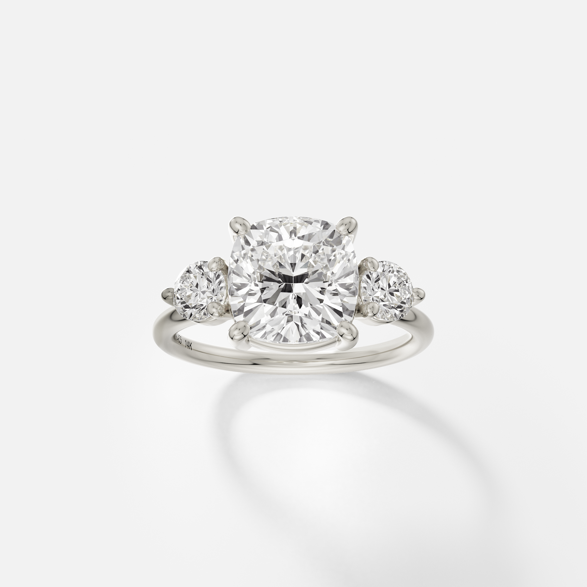 14k white gold three stone engagement ring with cushion-cut diamond center and round side stones in corner prongs