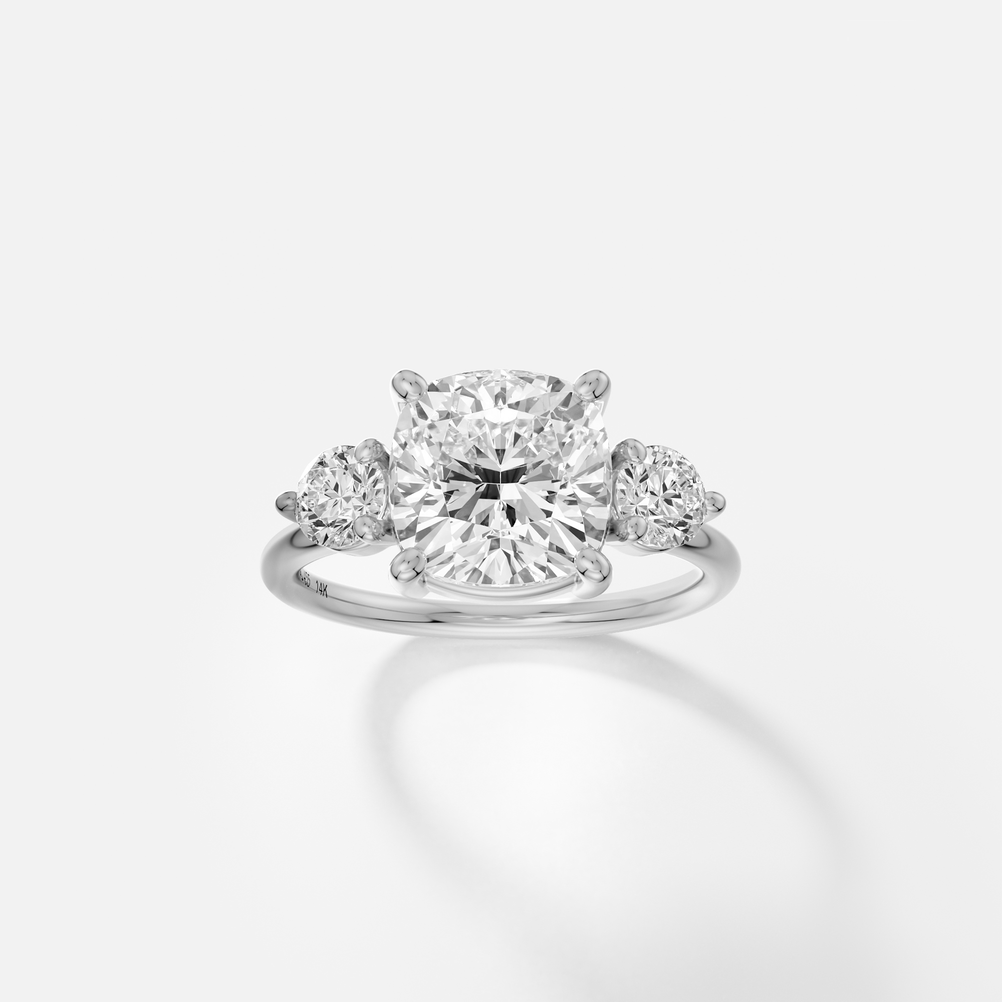 Platinum engagement ring with cushion-cut diamond center and round accent stones in corner prong setting on delicate band