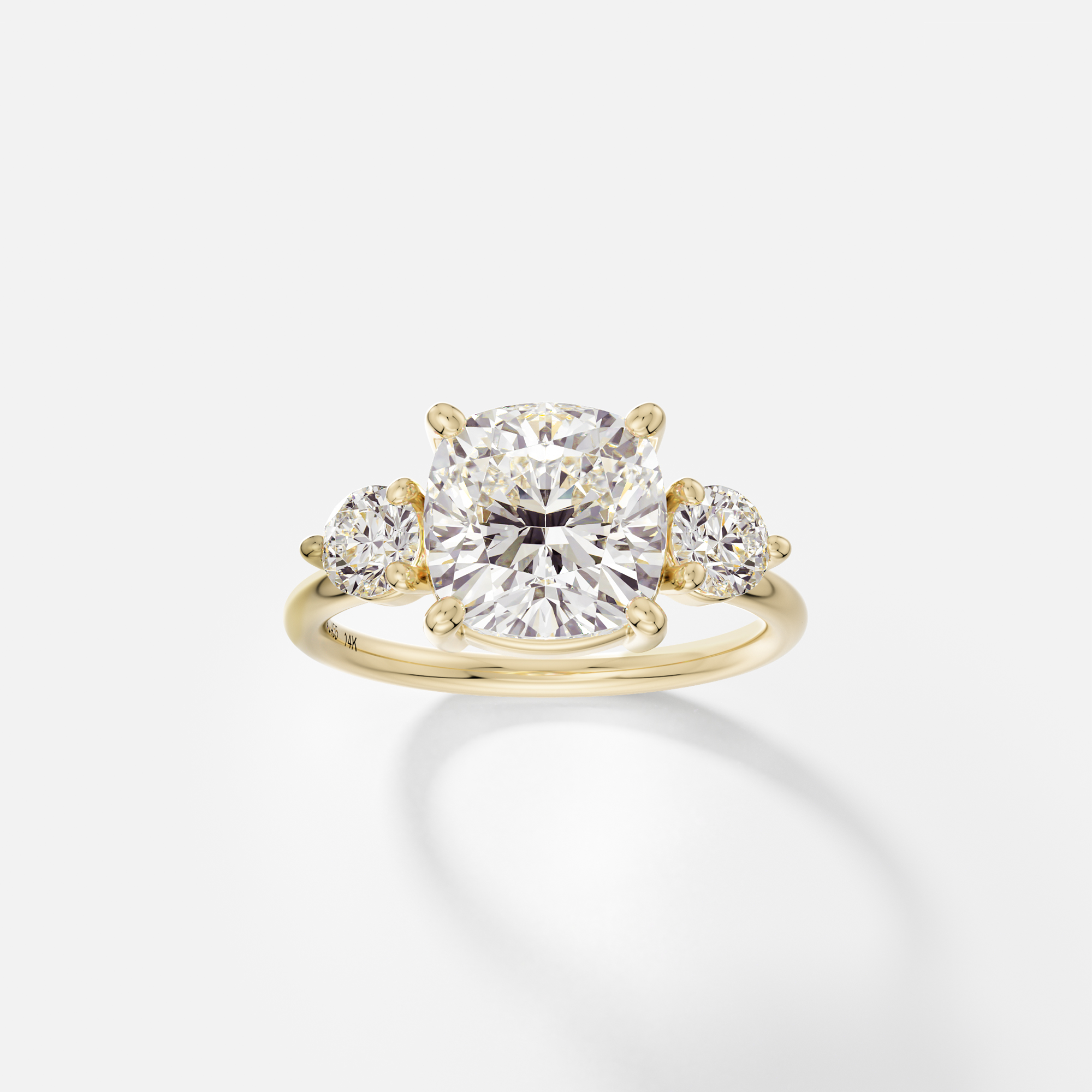 14k yellow gold three stone engagement ring with 3.25 carat cushion-cut diamond in corner prongs and round side stones on delicate round band