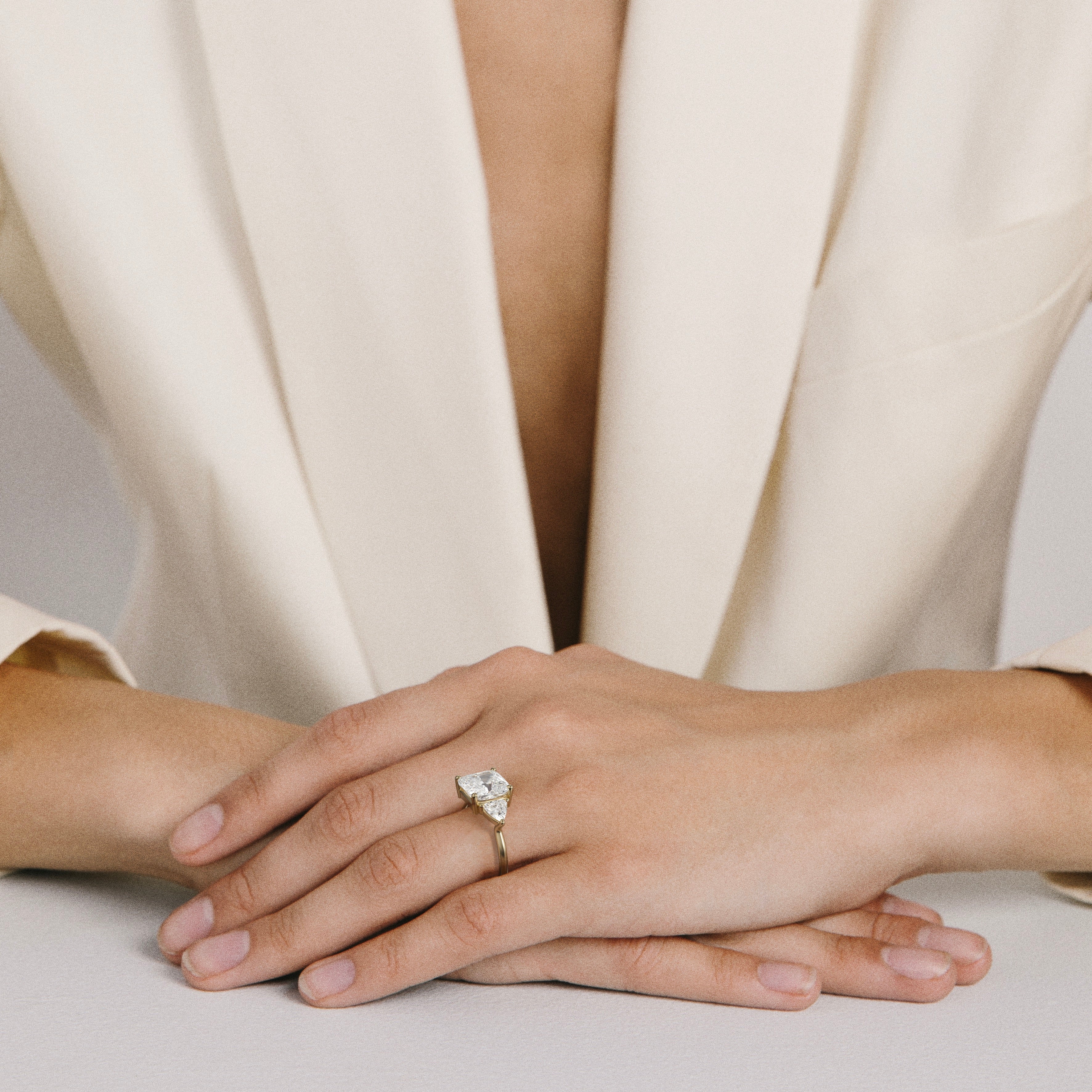 3.50 carat cushion diamond engagement ring with trillion side stones worn on hand