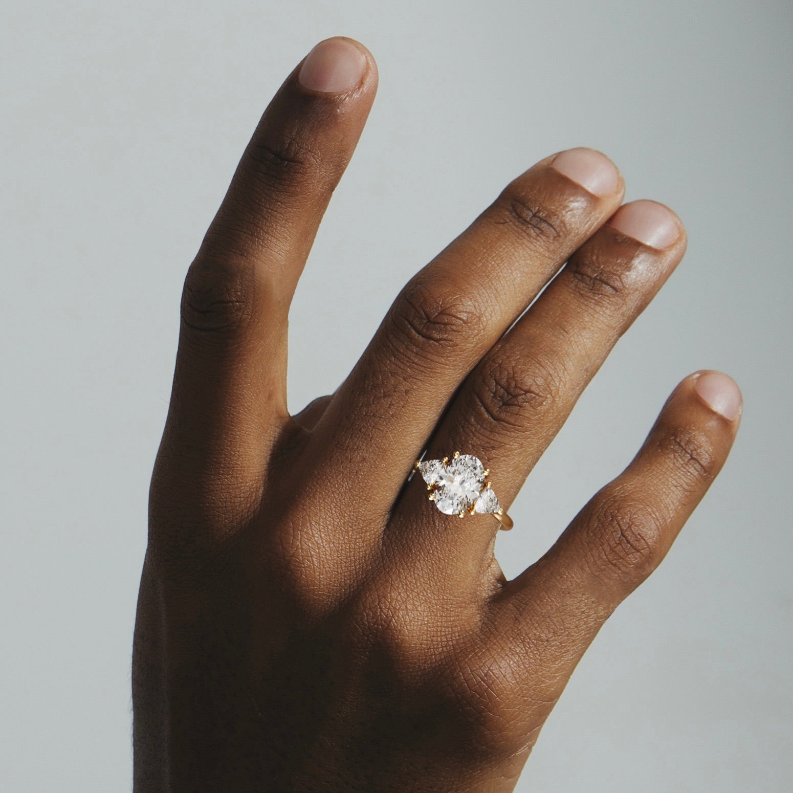 2.50 carat oval diamond engagement ring with trillion side stones worn on hand