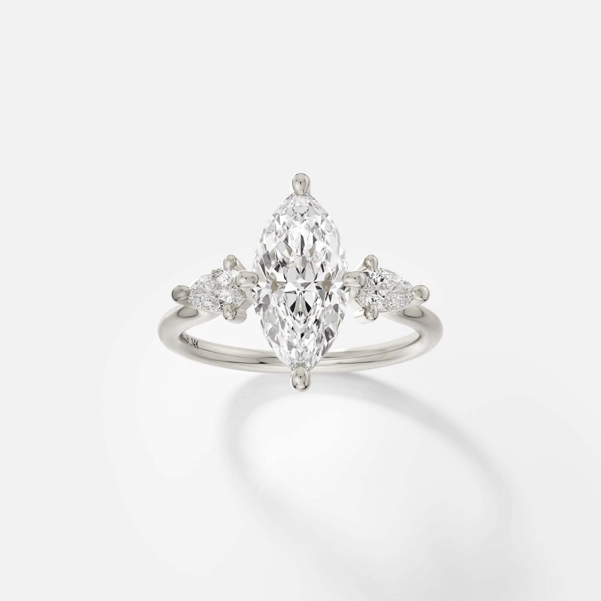 14k white gold engagement ring with 2.00 ct marquise diamond and pear-cut side stones in compass prong cluster setting