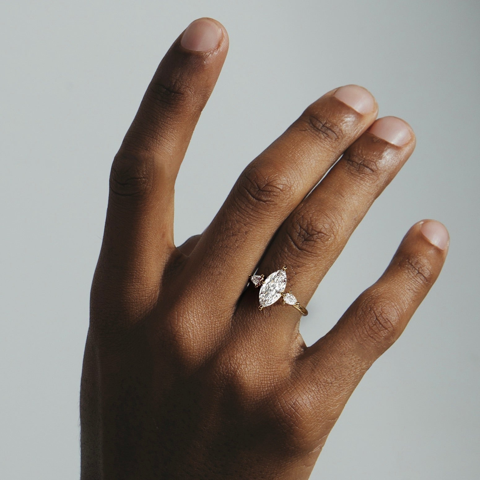 Kele marquise diamond pear three stone engagement ring worn on hand