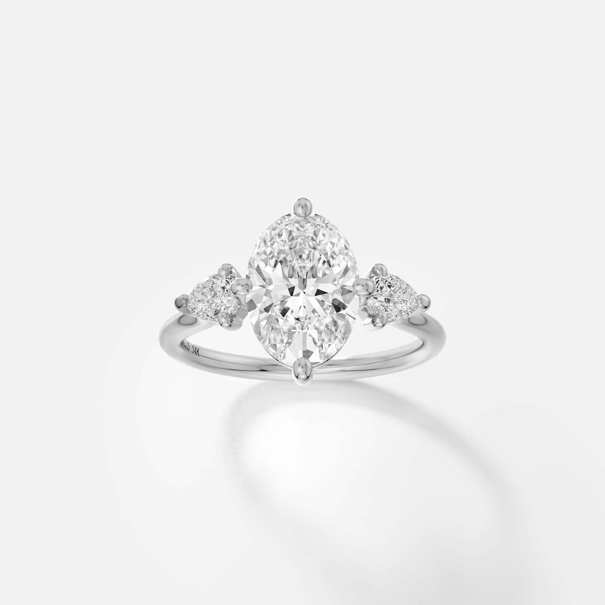 platinum engagement ring with 2.00 carat oval diamond and pear side stones in compass prong setting on thin round band