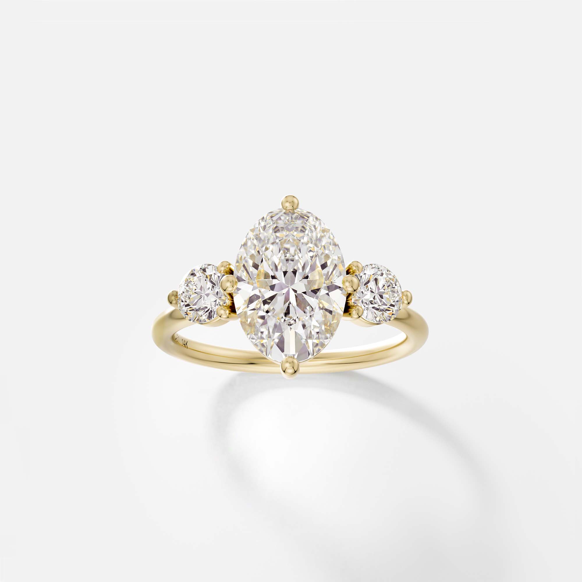 Kele oval three stone diamond engagement ring with round side stones front view in 14k yellow gold