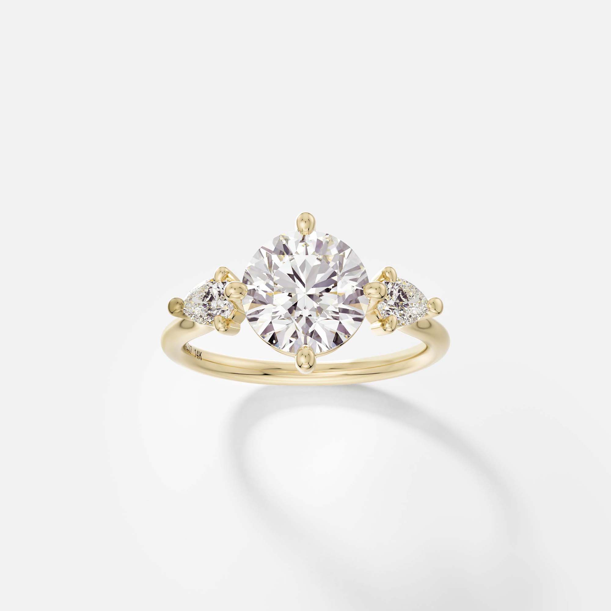14k yellow gold three stone engagement ring with 2.00 carat round brilliant diamond and pear-cut side stones in compass prongs on delicate round profile band open setting