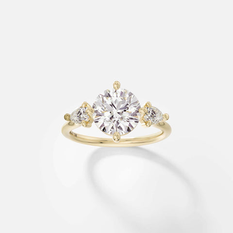 14k yellow gold three stone engagement ring with 2.00 carat round brilliant diamond and pear-cut side stones in compass prongs on delicate round profile band open setting