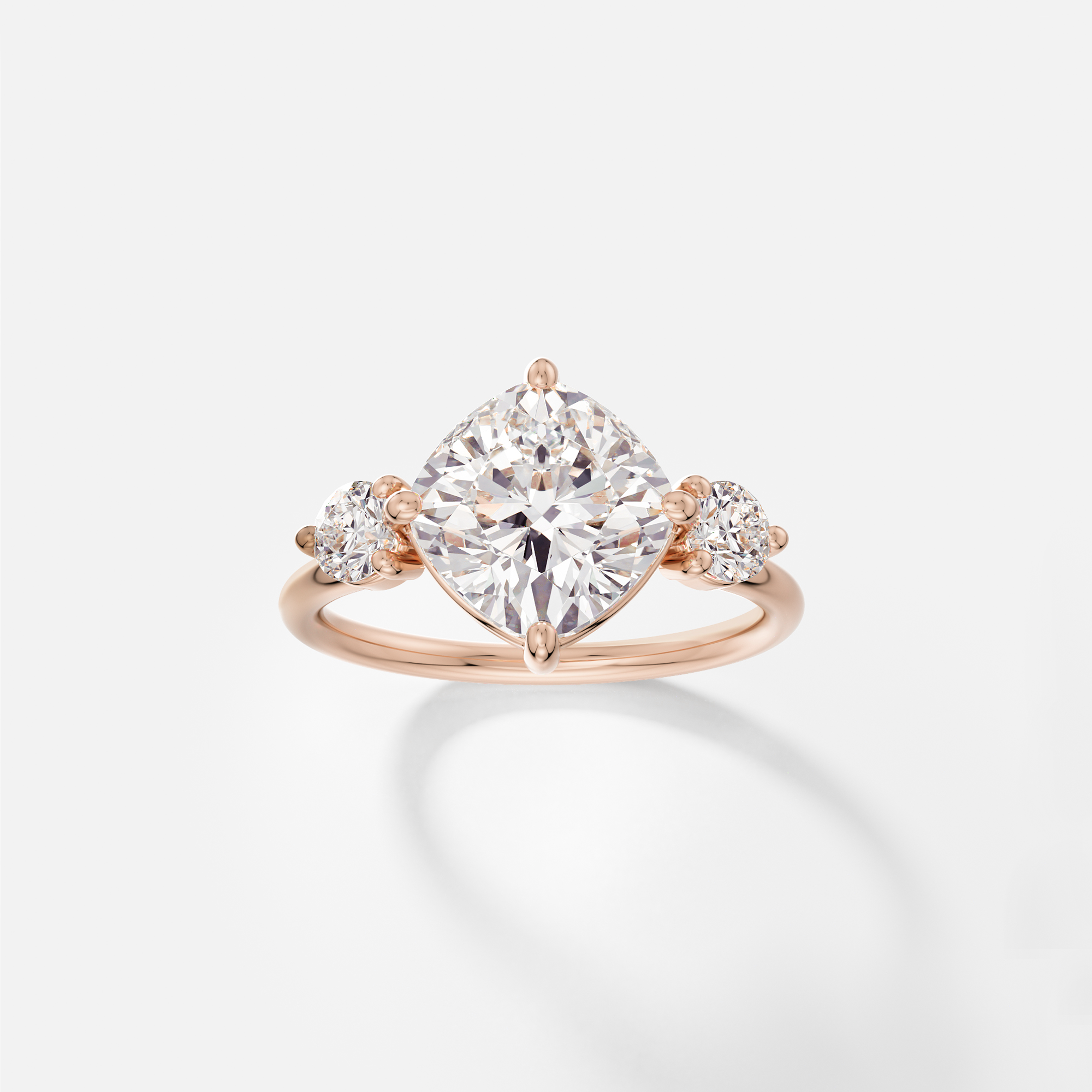 14k rose gold engagement ring with tilted cushion-cut diamond set in compass prongs on round profile band