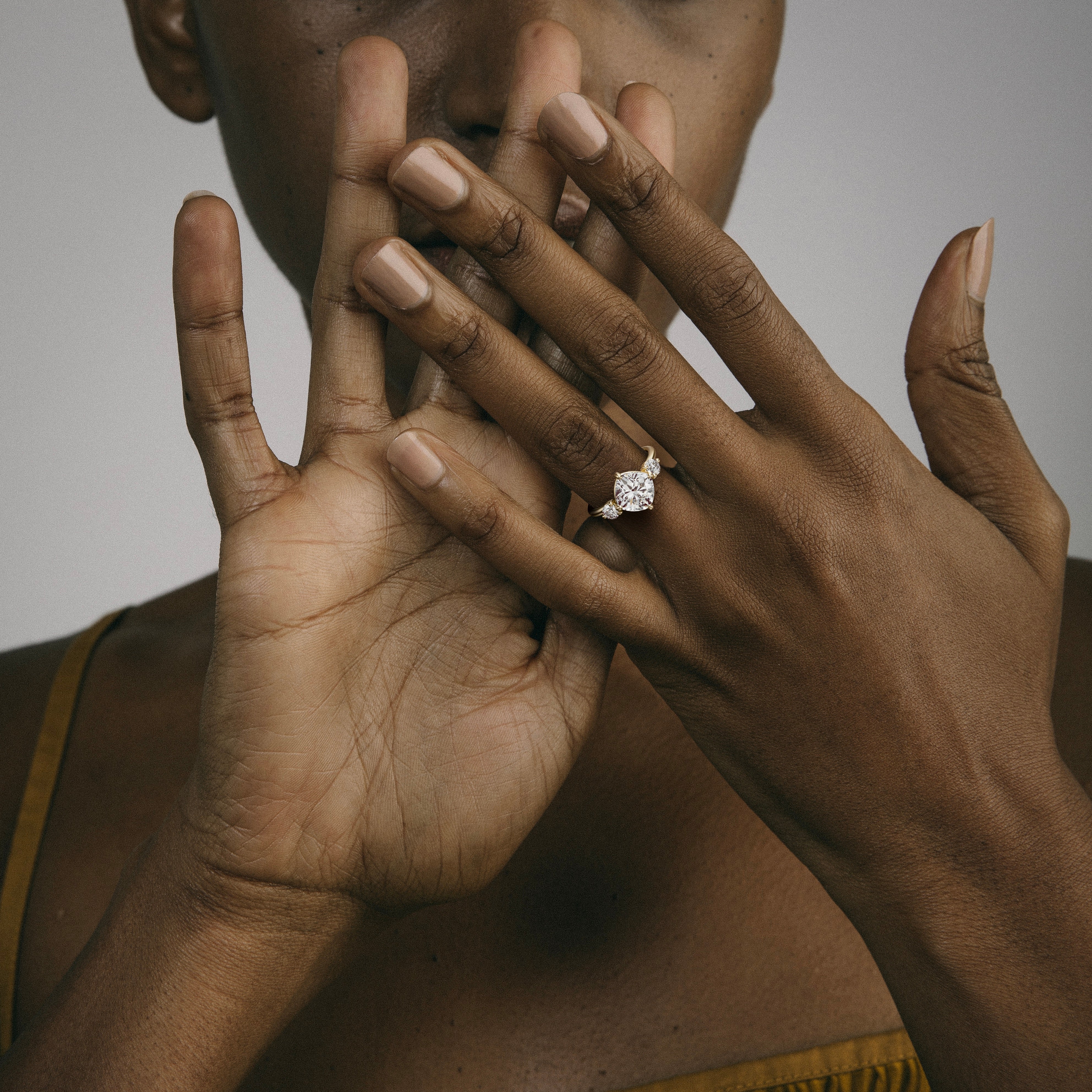 14k yellow gold engagement ring with tilted cushion diamond in compass prongs worn on hand