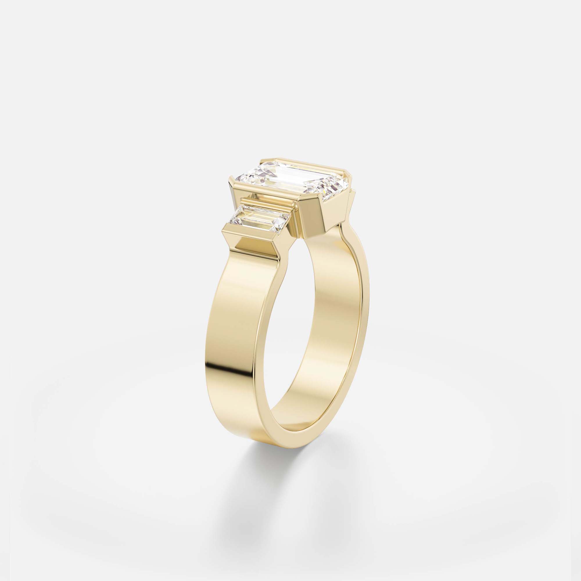 emerald-cut diamond three stone engagement ring with baguette side stones in streamlined partial bezel settings on flat band