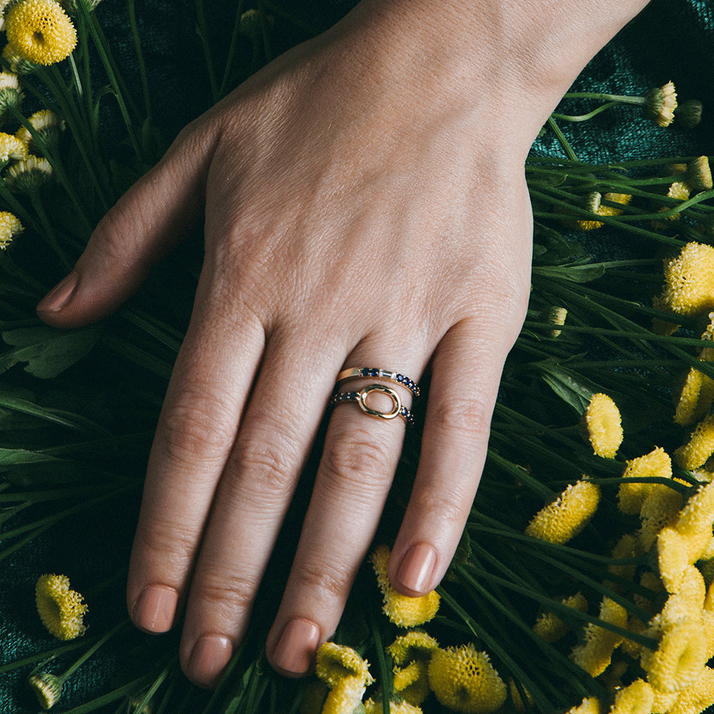Thin sapphire and diamond band worn stacked with other gold rings