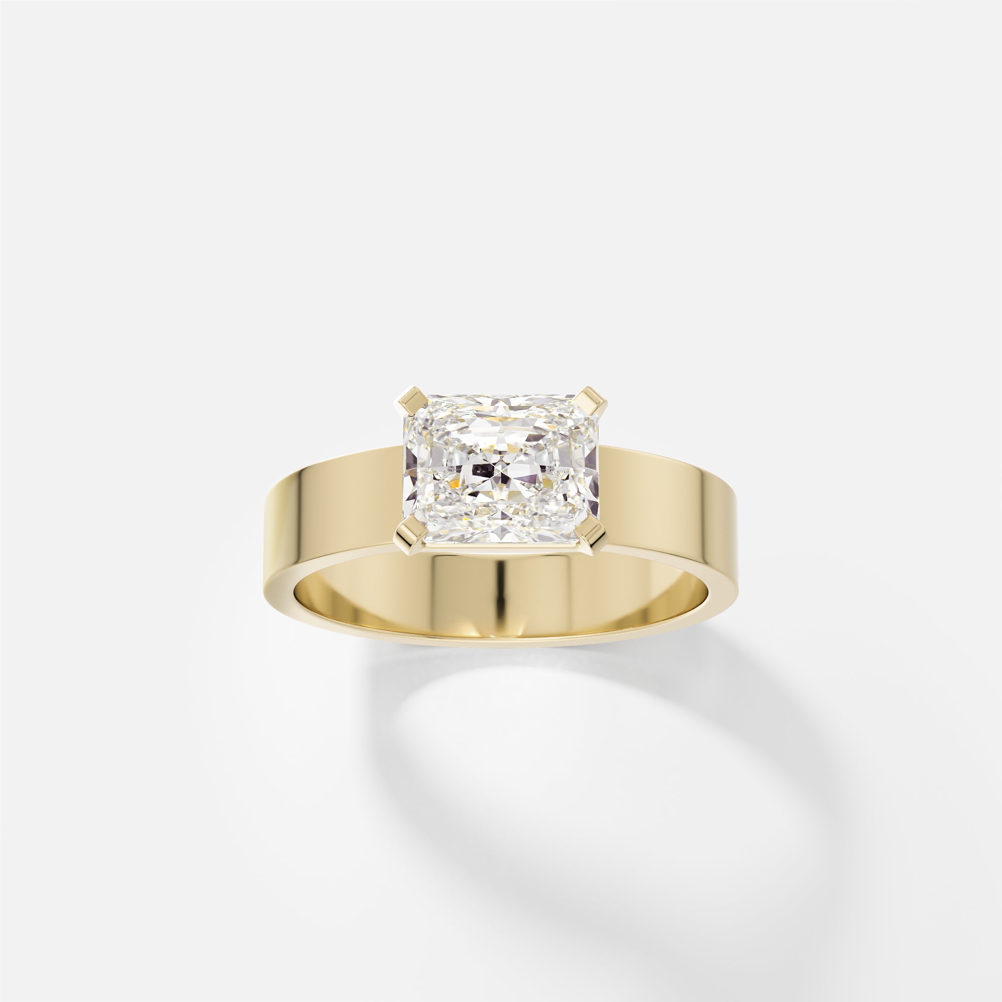 14k yellow gold engagement ring with 1.50 carat radiant-cut diamond set east west in corner prongs on flat profile band