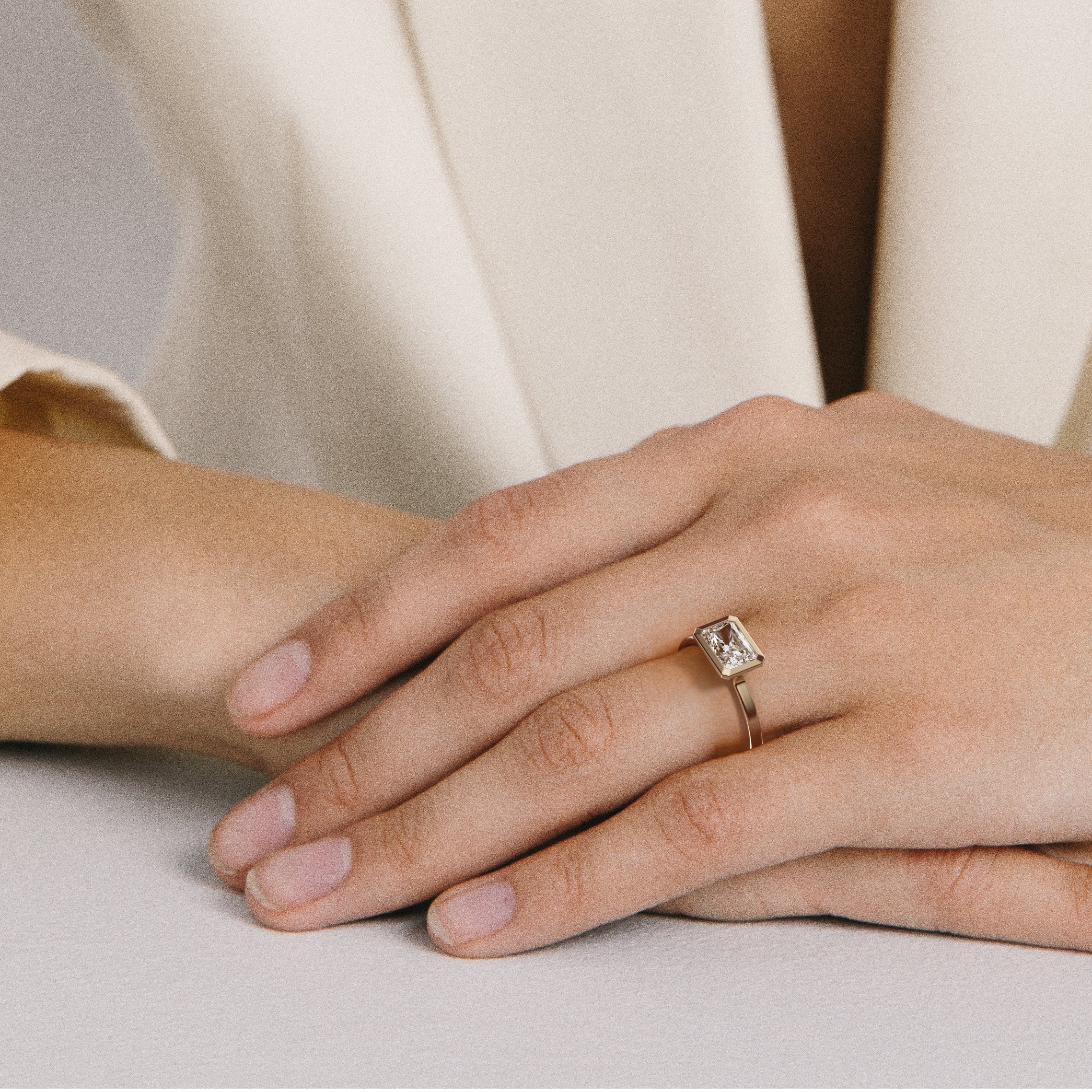 Close view of radiant-cut diamond set east west in thin bezel on flat profile band