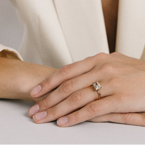 Close view of radiant-cut diamond set east west in thin bezel on flat profile band