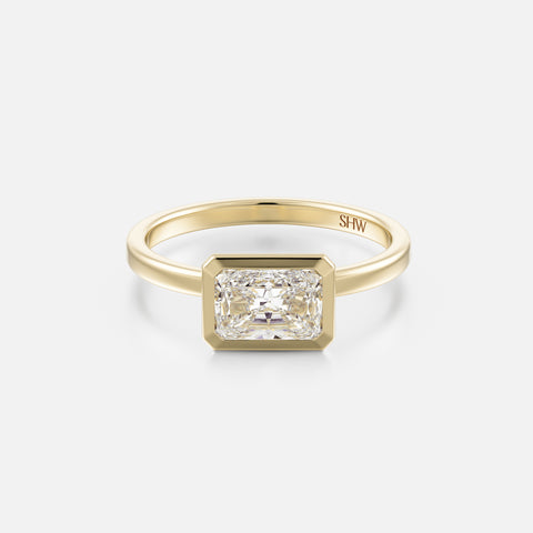 14k yellow gold thin flat band engagement ring with 1.00 carat east-west radiant-cut diamond in bezel setting