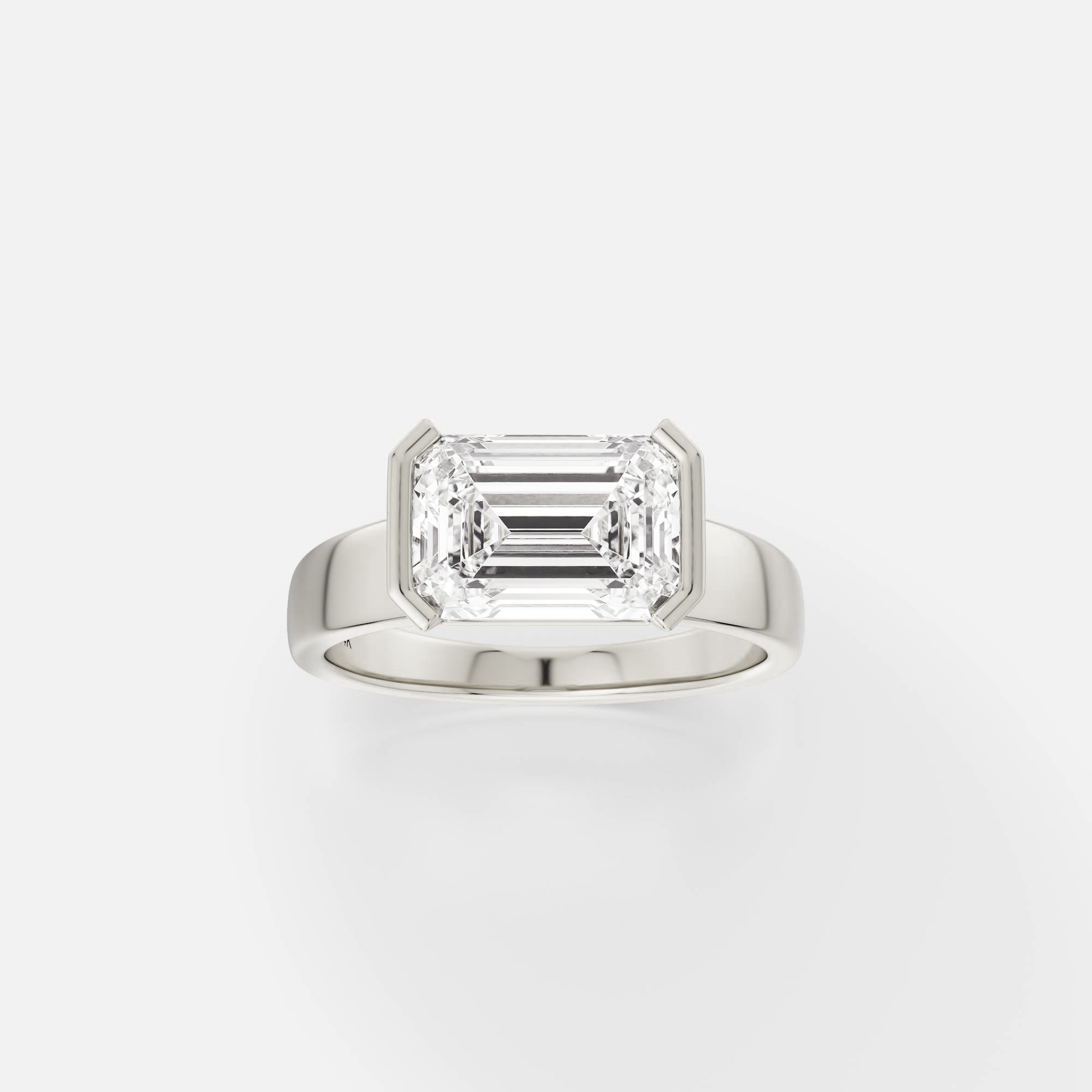 14k white gold engagement ring with 2.75 ct east-west emerald-cut diamond in tapering partial bezel setting