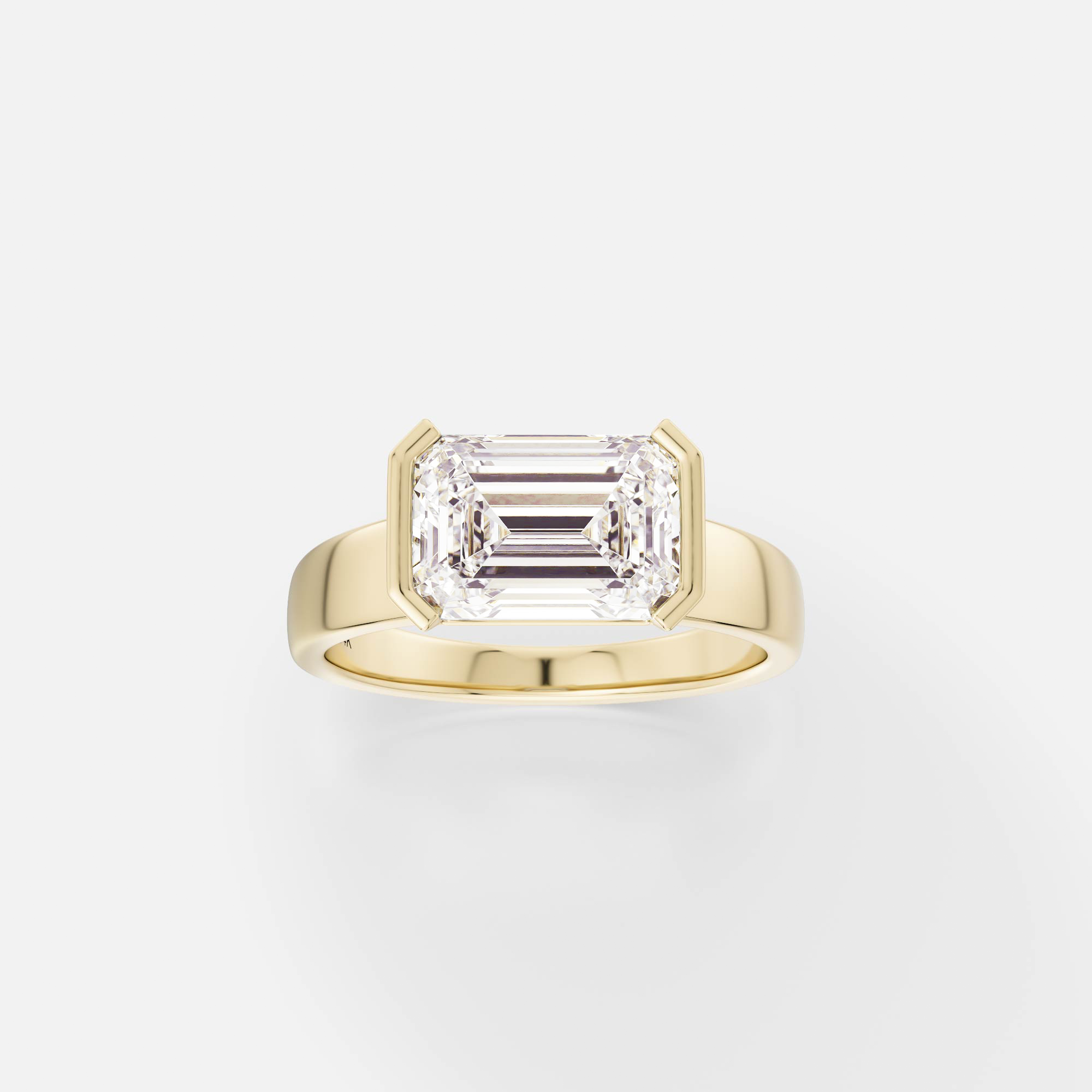 14k yellow gold engagement ring with 2.75 carat east-west emerald-cut diamond in tapering partial bezel on tapered band
