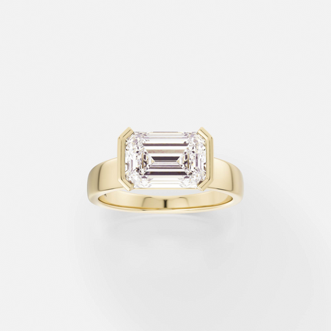 14k yellow gold engagement ring with 2.75 carat east-west emerald-cut diamond in tapering partial bezel on tapered band