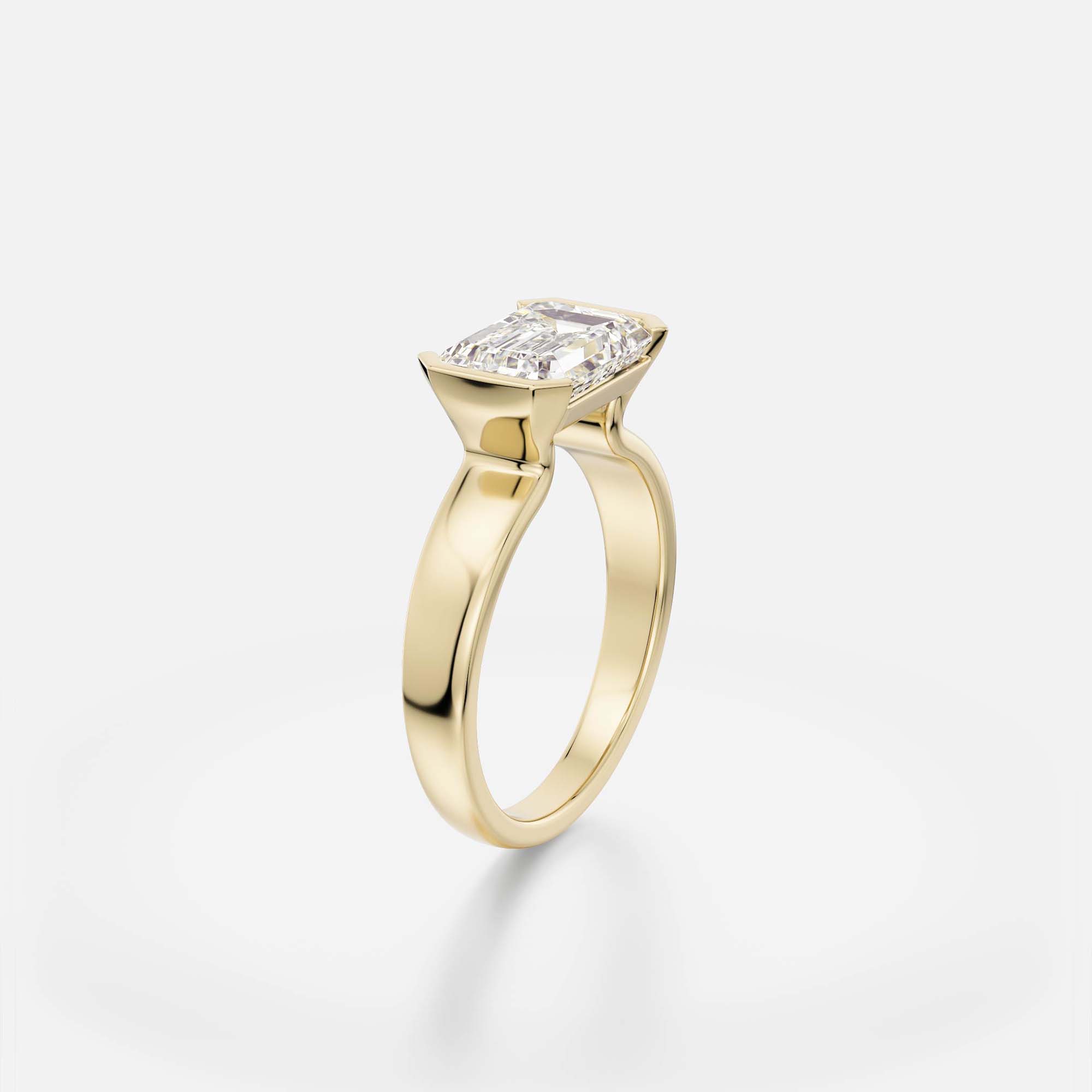 2.75 ct east west emerald cut diamond engagement ring with tapered partial bezel setting on sculptural band