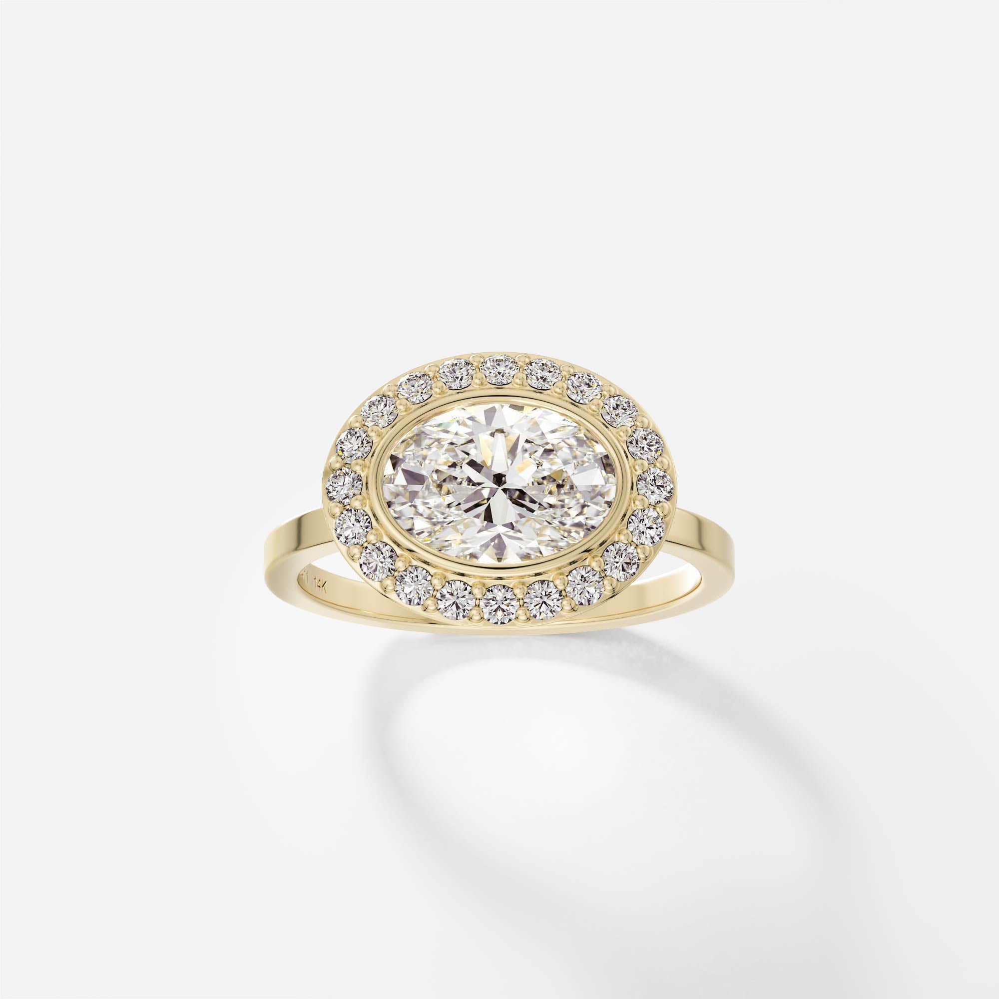 14k yellow gold halo engagement ring with 1.50 carat oval diamond set east west in bezel with pavé diamond halo