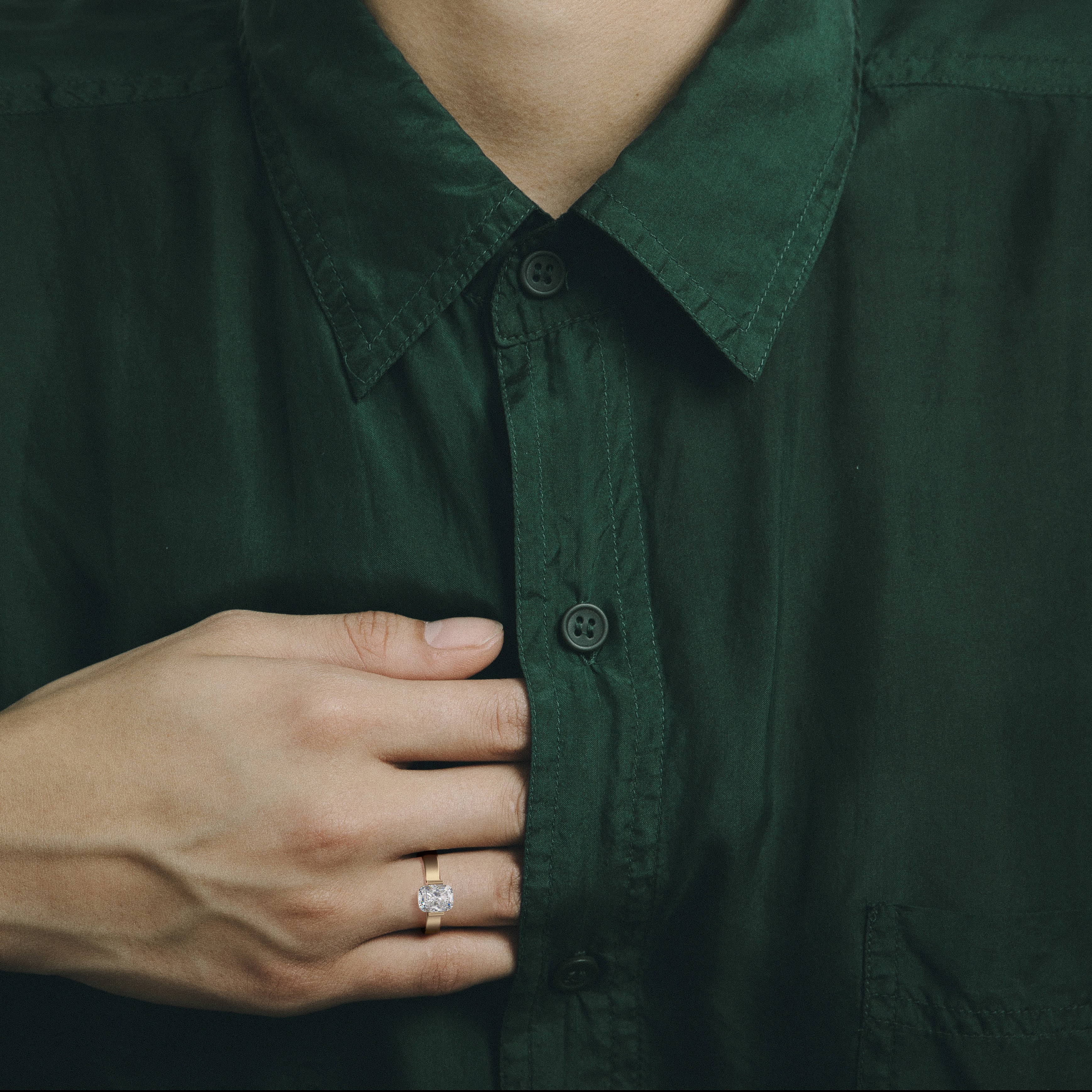 Sculptural yellow gold engagement ring with elongated cushion diamond worn on hand