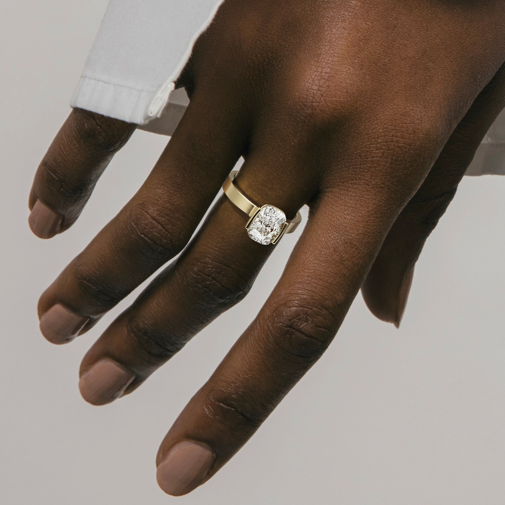 close view of 2.00 ct cushion-cut diamond engagement ring in tapering partial bezel on wide band