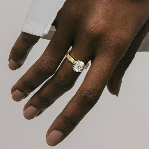 close view of 2.00 ct cushion-cut diamond engagement ring in tapering partial bezel on wide band