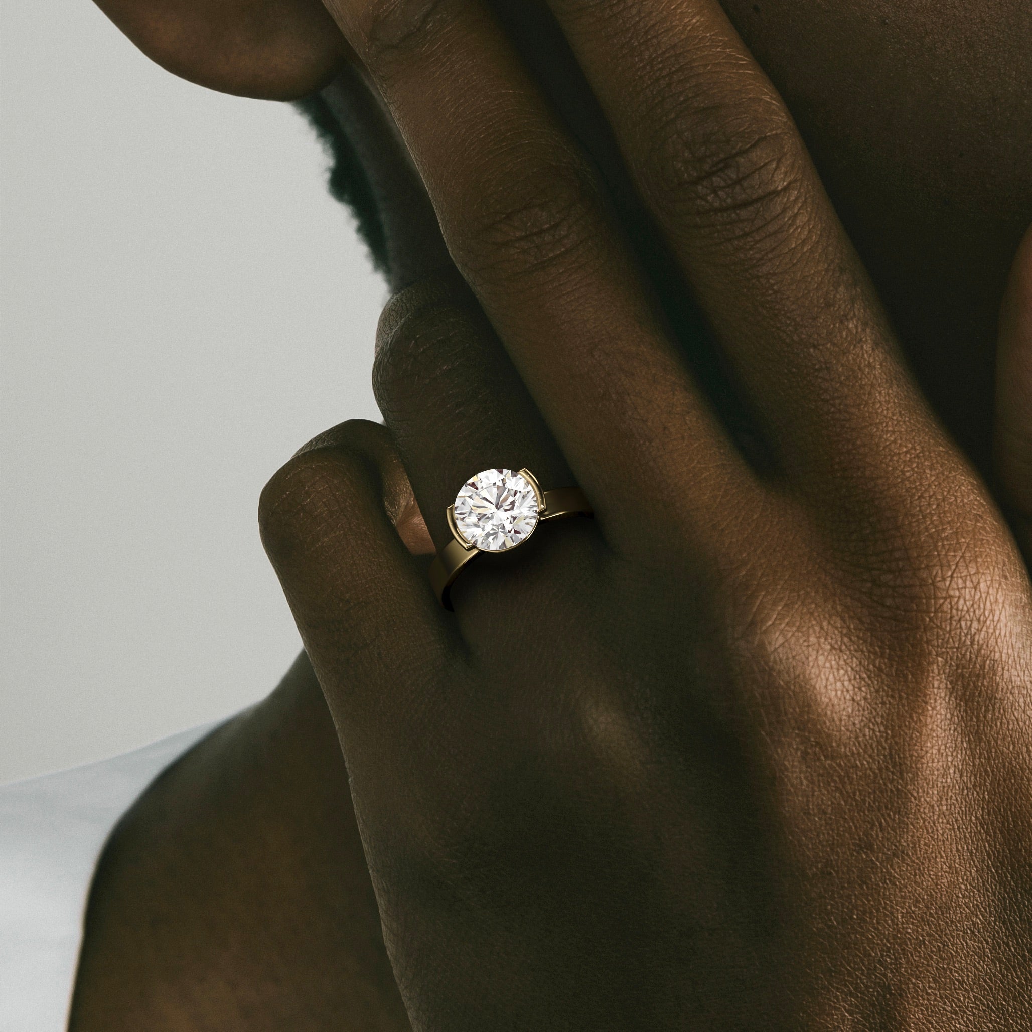 close view of 2.50 ct round brilliant diamond engagement ring in tapering partial bezel on wide band