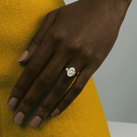 close view of 3.00 ct oval diamond engagement ring in tapering partial bezel on wide band