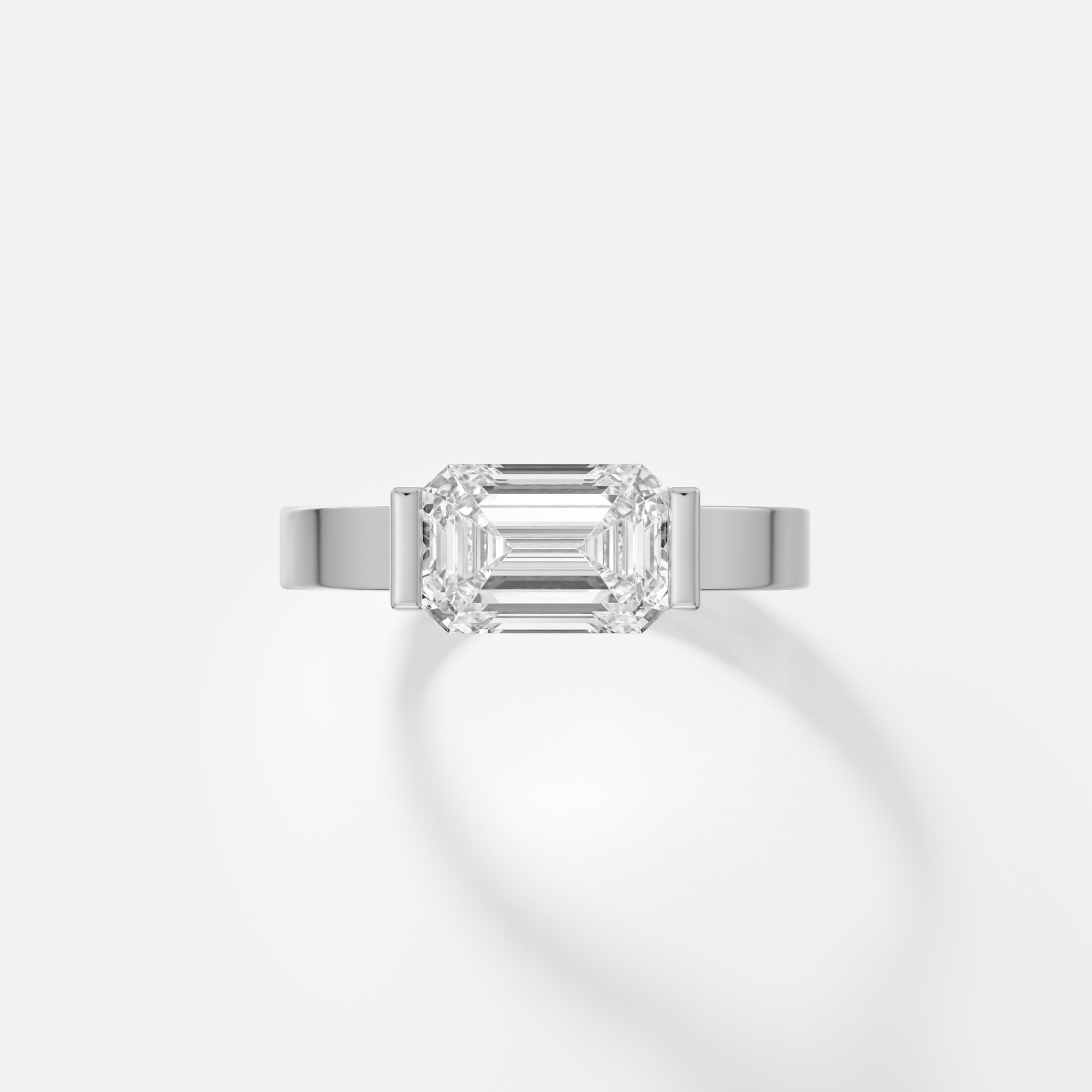Silvi east west emerald cut diamond tapered bezel ring front view in platinum