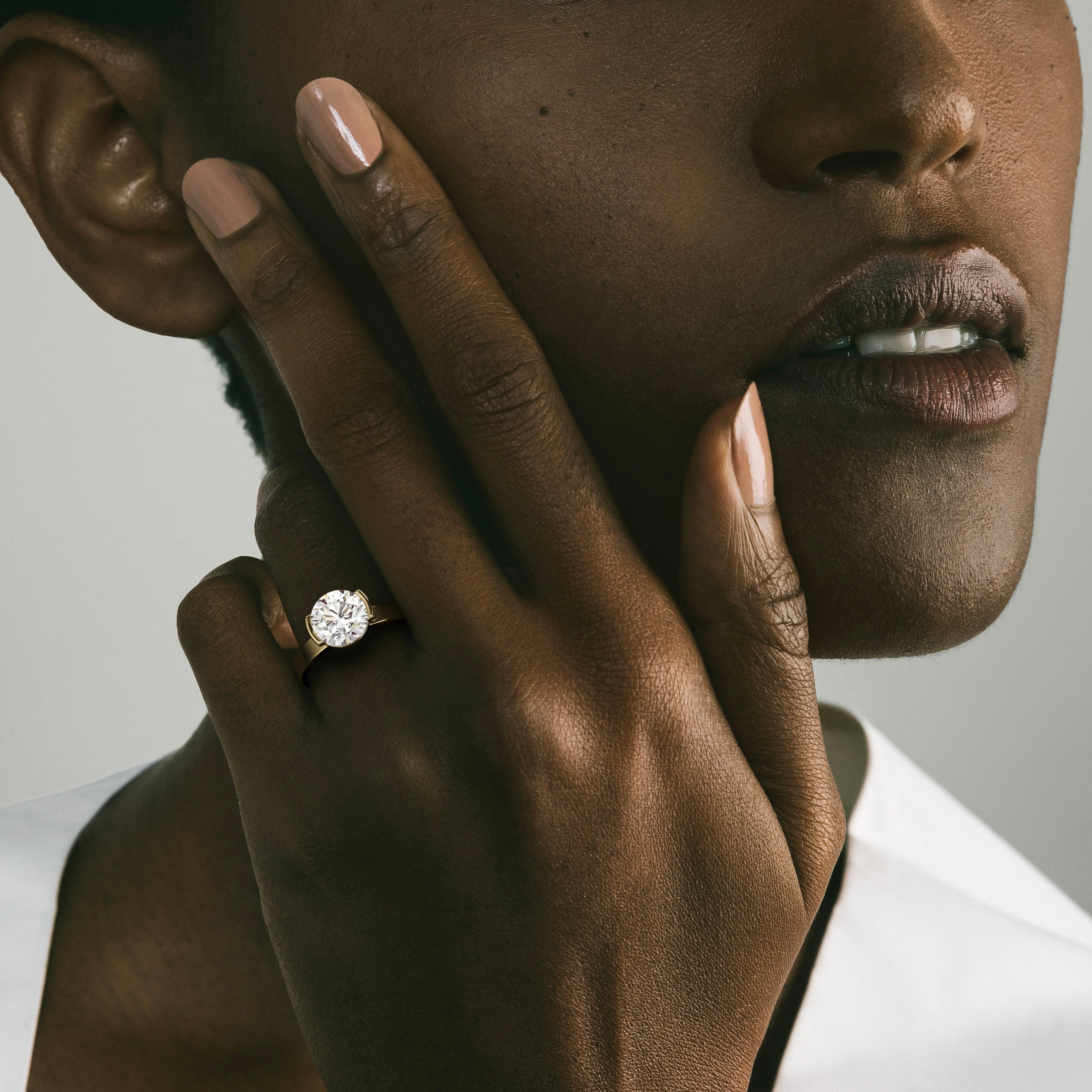 2.50 carat round brilliant diamond engagement ring in tapered partial bezel setting worn on hand