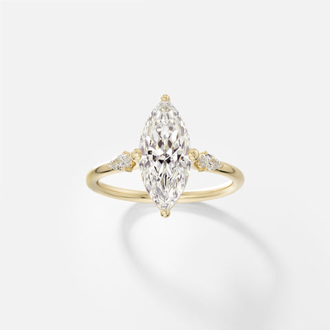 14k yellow gold three stone engagement ring with 1.75 carat marquise diamond in compass prongs and pear-cut accent stones on delicate round band