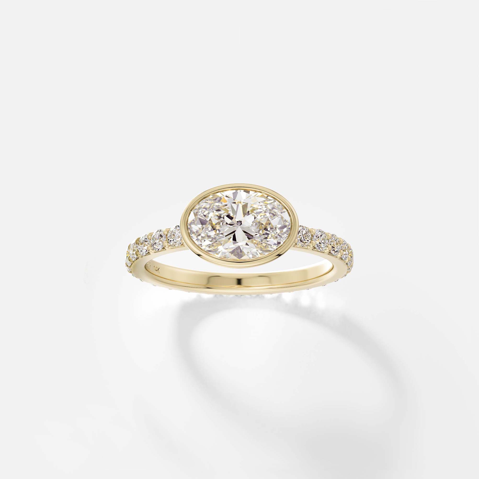 Tulpe east west oval diamond bezel pavé band ring front view in 14k yellow gold