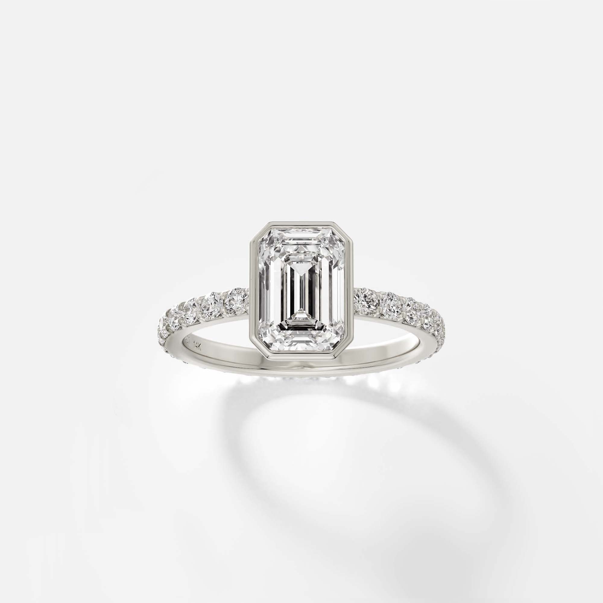 14k white gold engagement ring with emerald-cut diamond bezel setting and pavé diamond half eternity band