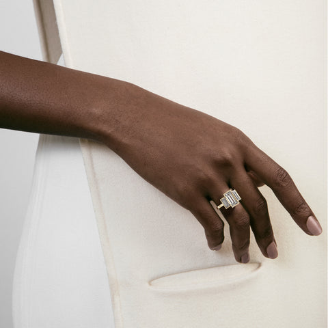 14k yellow gold three stone engagement ring with baguette-cut diamonds worn on hand