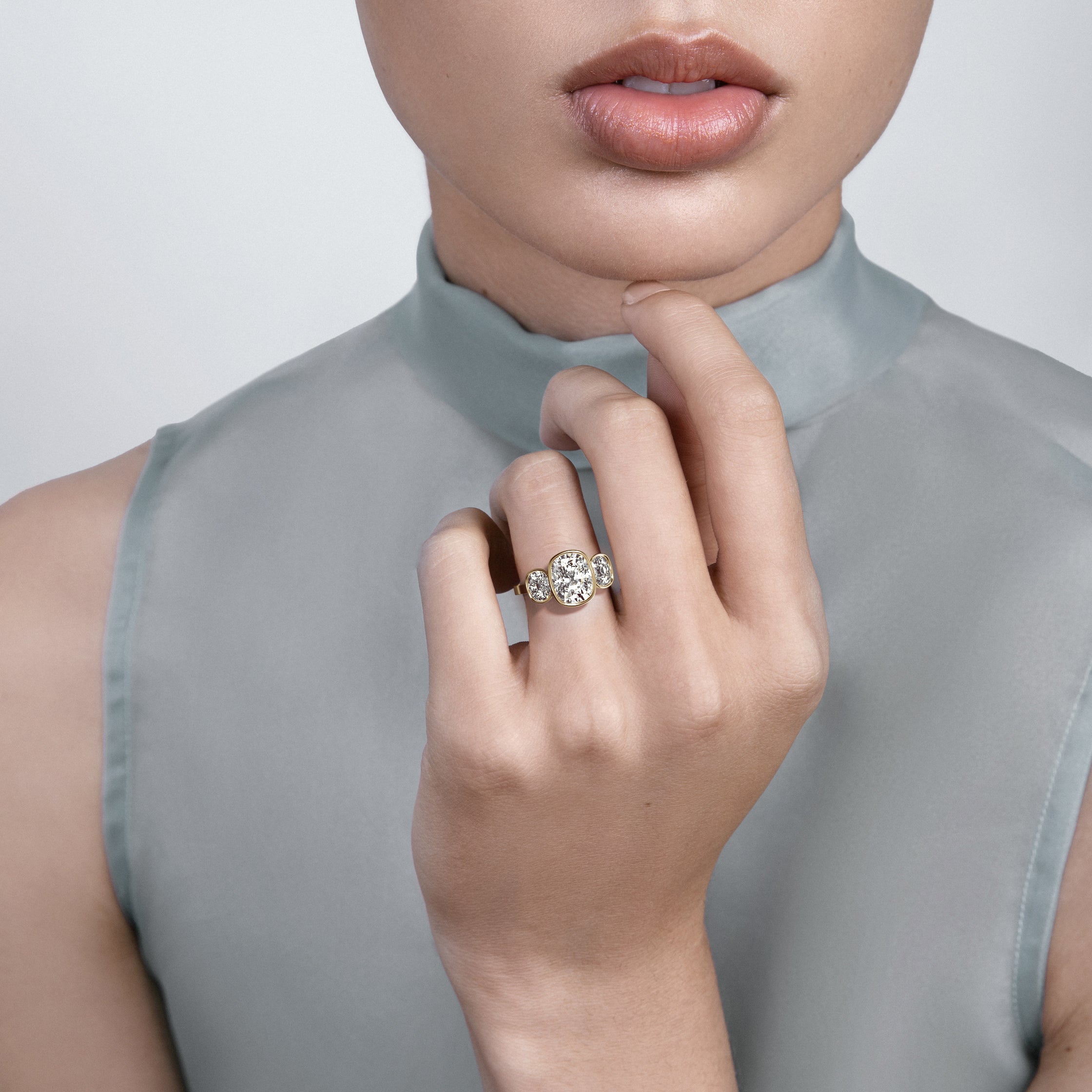 Tyra three elongated cushion diamond engagement ring worn on hand