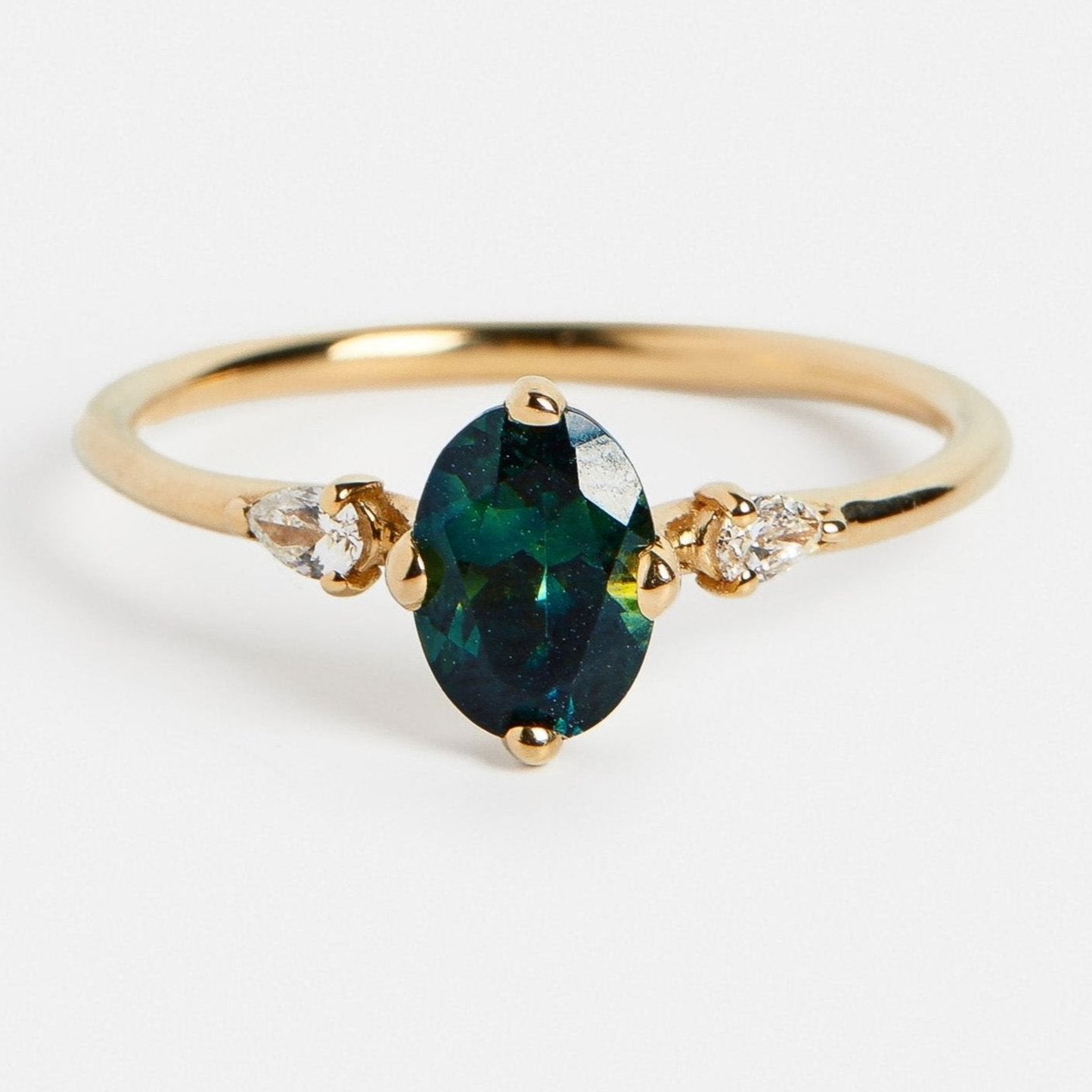 Modern stones on side engagement ring setting with deep blue 1 carat sapphire and pear shape diamonds in 14k yellow gold by SHW jewelry NYC