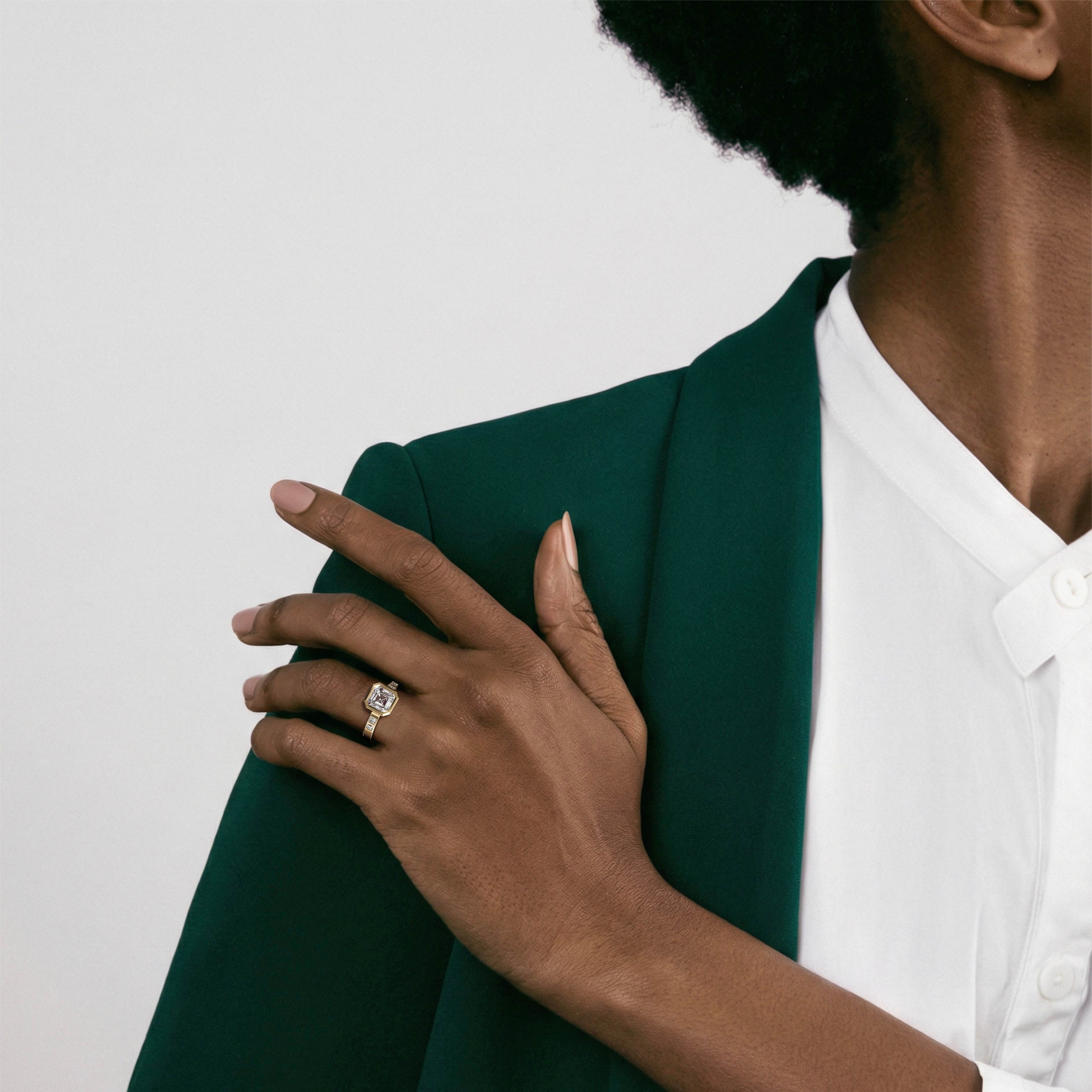 asscher-cut diamond engagement ring with princess-cut diamonds set along the band worn on hand