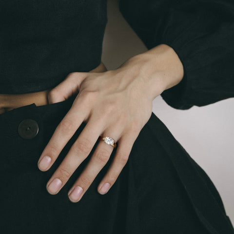 2.00 carat east-west cushion diamond engagement ring with tapering partial bezel worn on hand